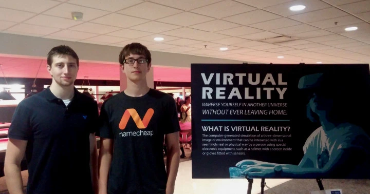 Galen and Mikhail beside a virtual reality display at an early club event.